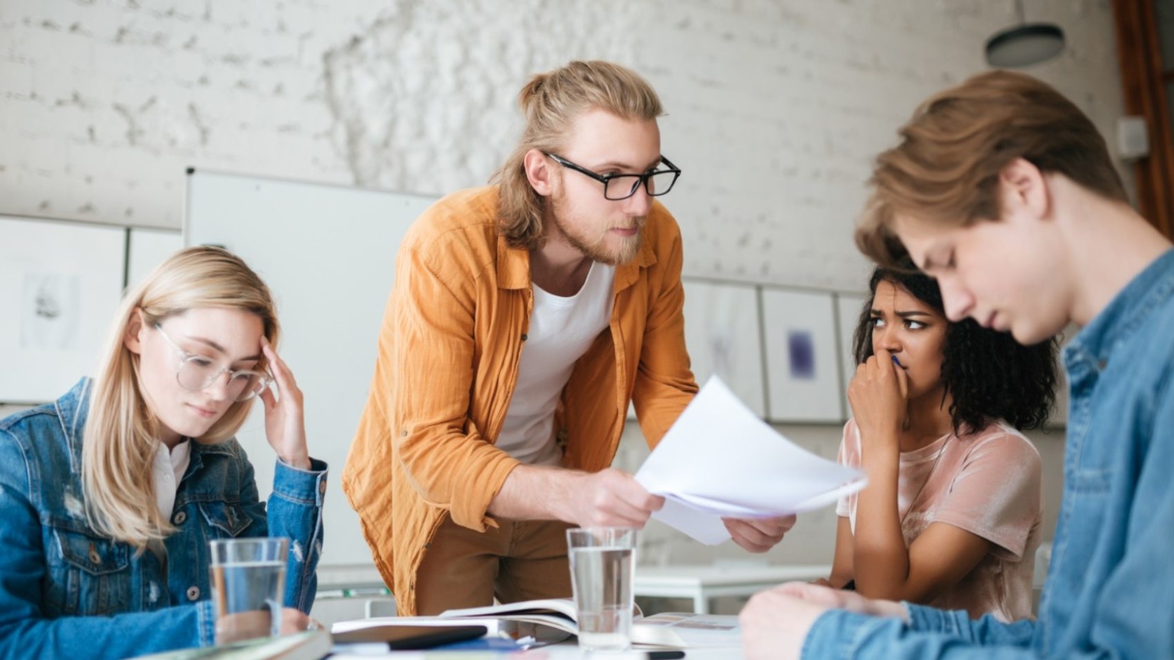group-of-upset-students-sitting-at-the-table-with-E5YW9L4