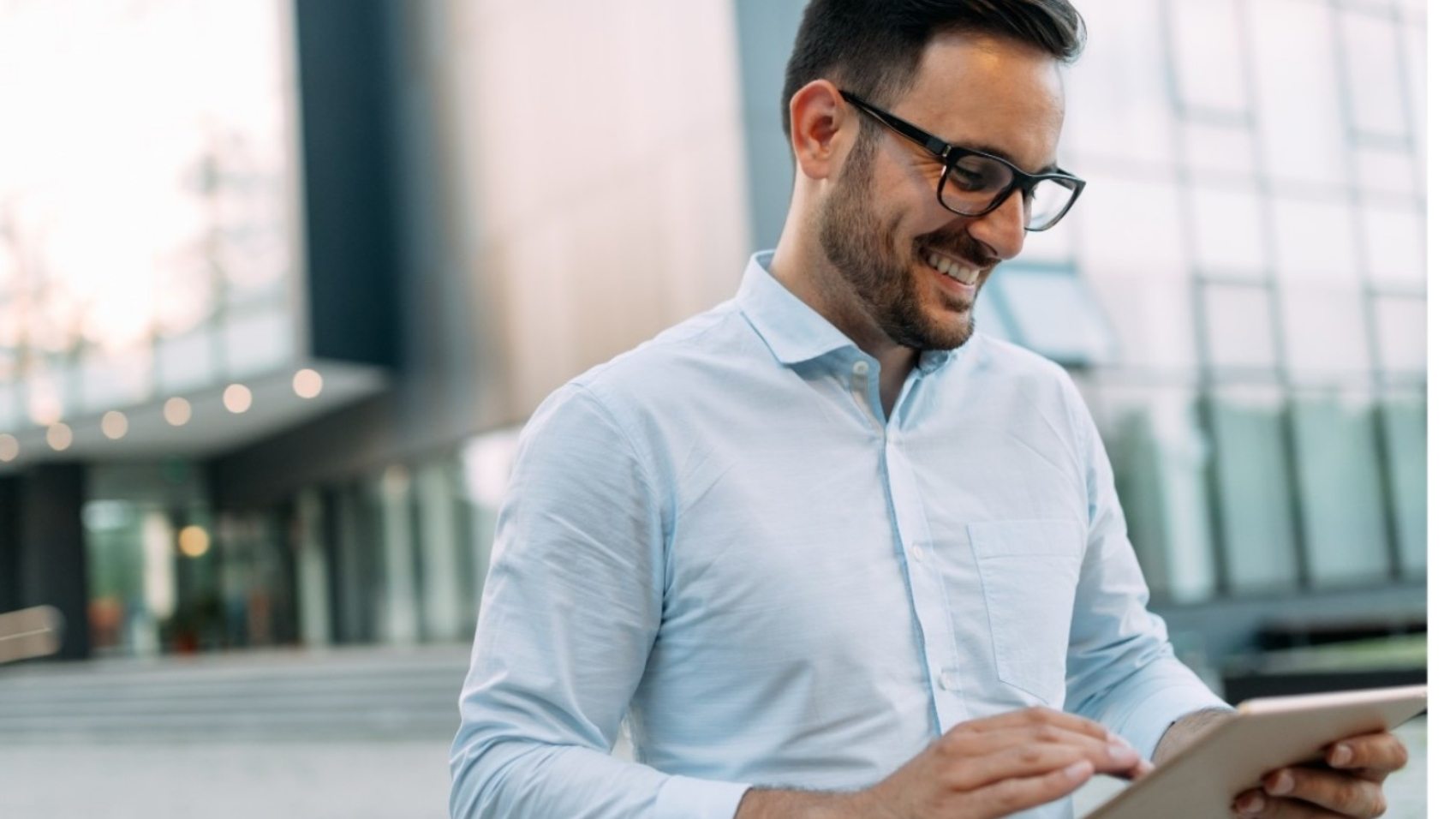 portrait-of-businessman-in-glasses-holding-tablet-AWVHCJU